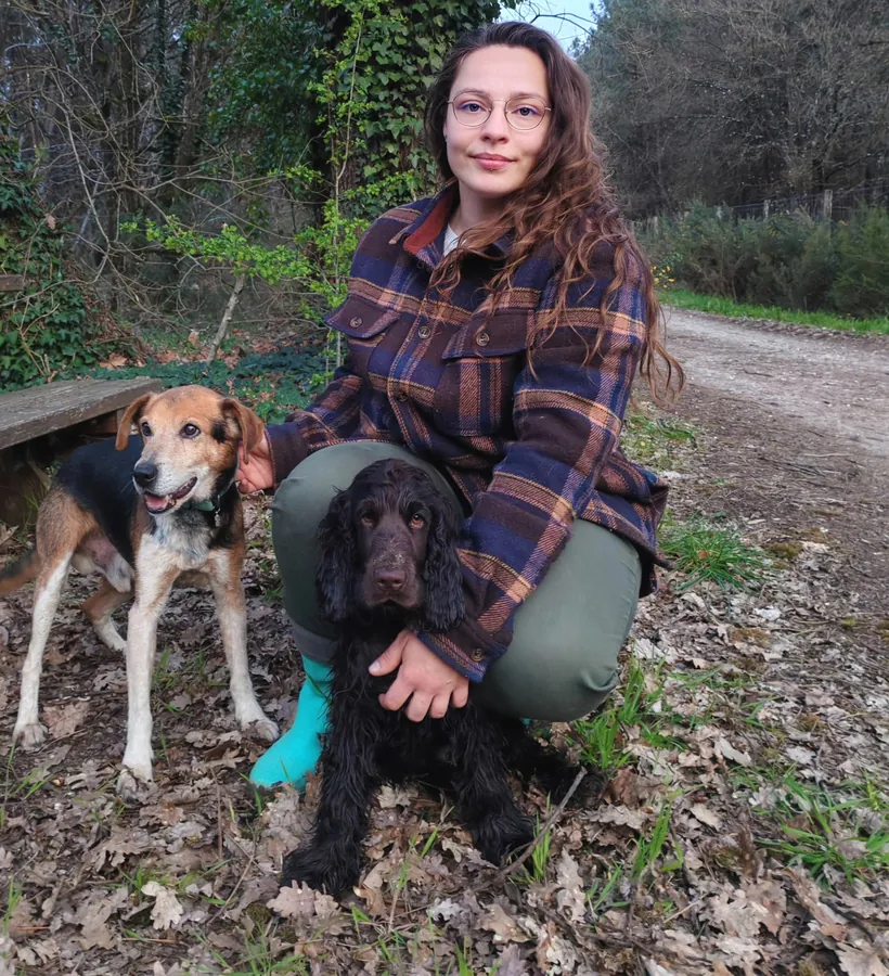 Éducatrice canine et toiletteuse de Passion Happy Dog accompagnée de ses deux chiens en forêt